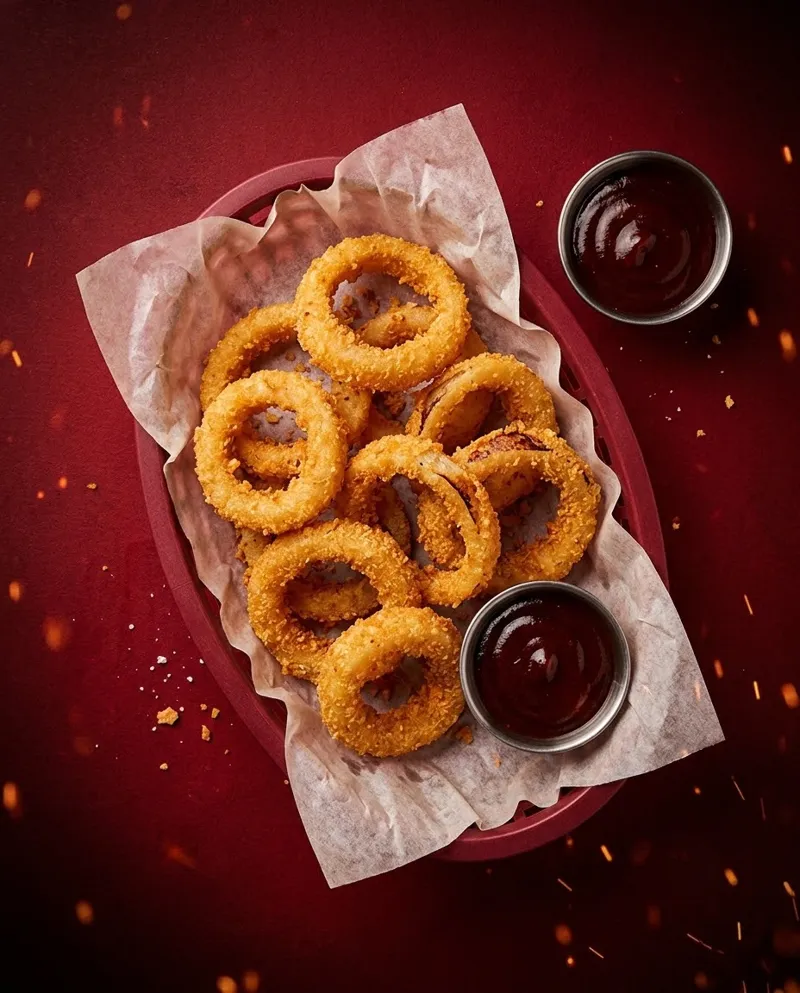 Anéis de cebola empanados com molho barbecue